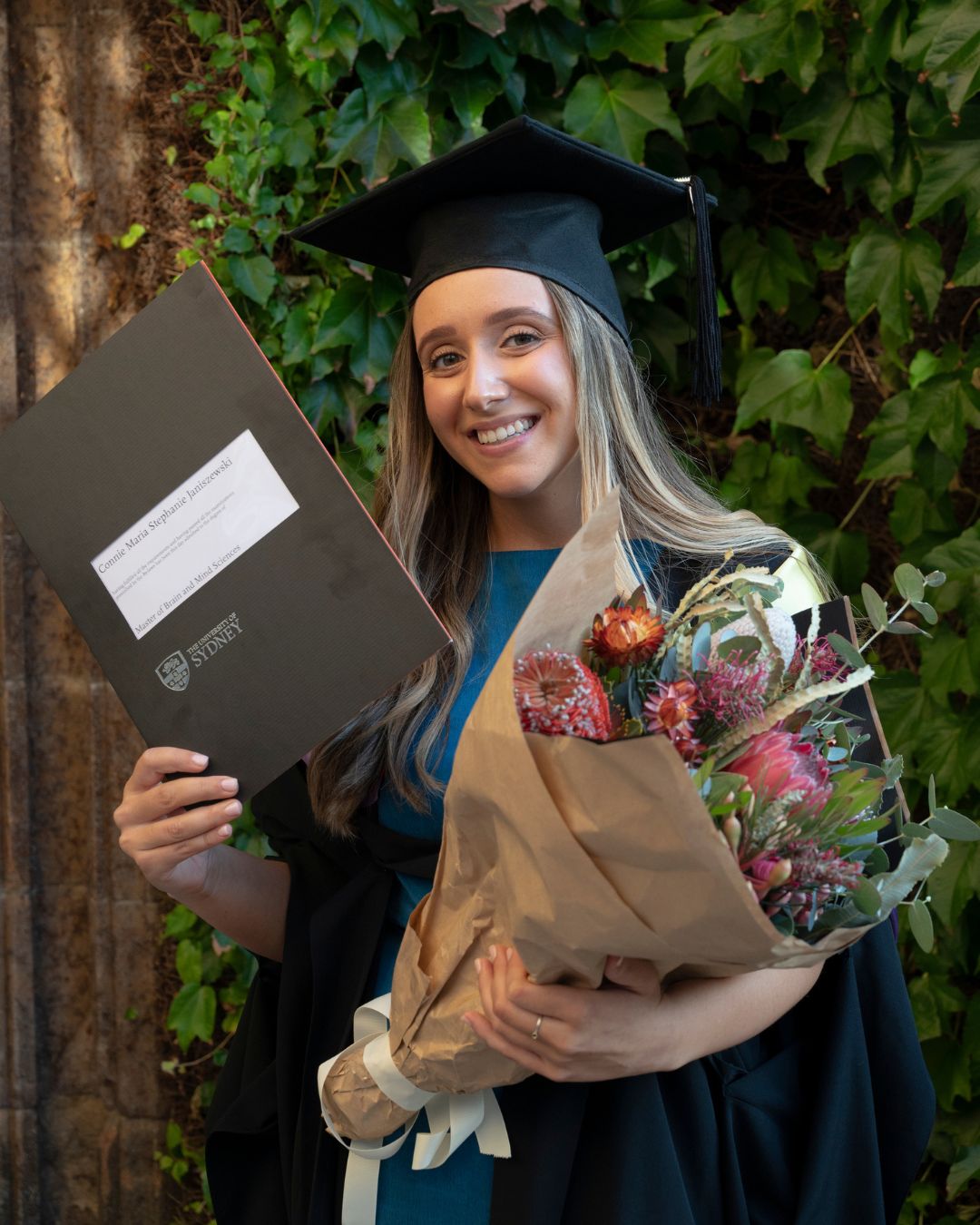 a women holding flowers and graduation hat
