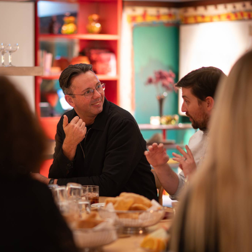 two man speaking at table in soicla setting