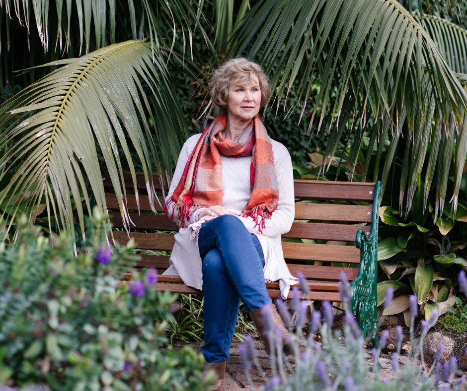 Woman sitting on a bench in a park.