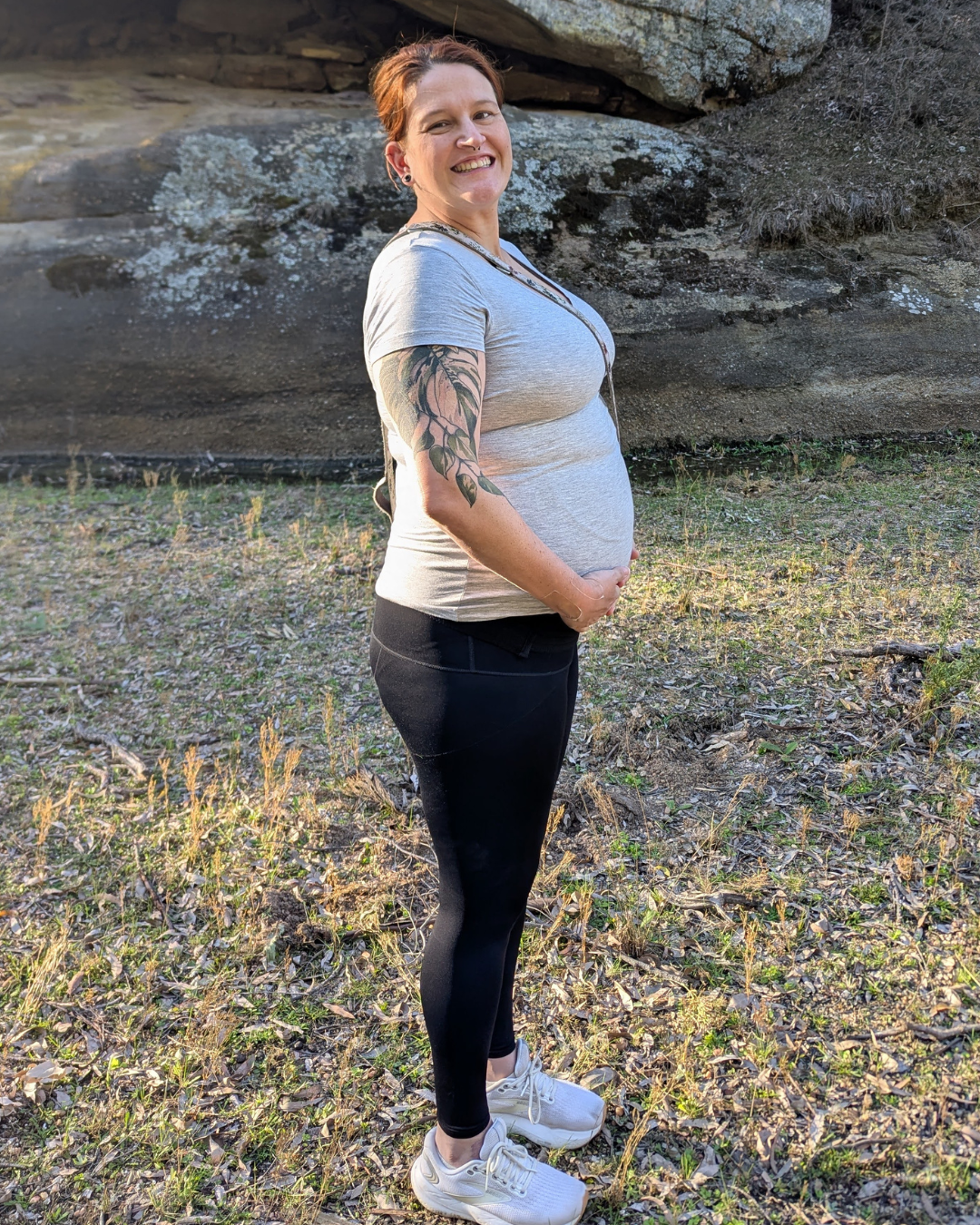 a pregnant woman holding her belly smiling