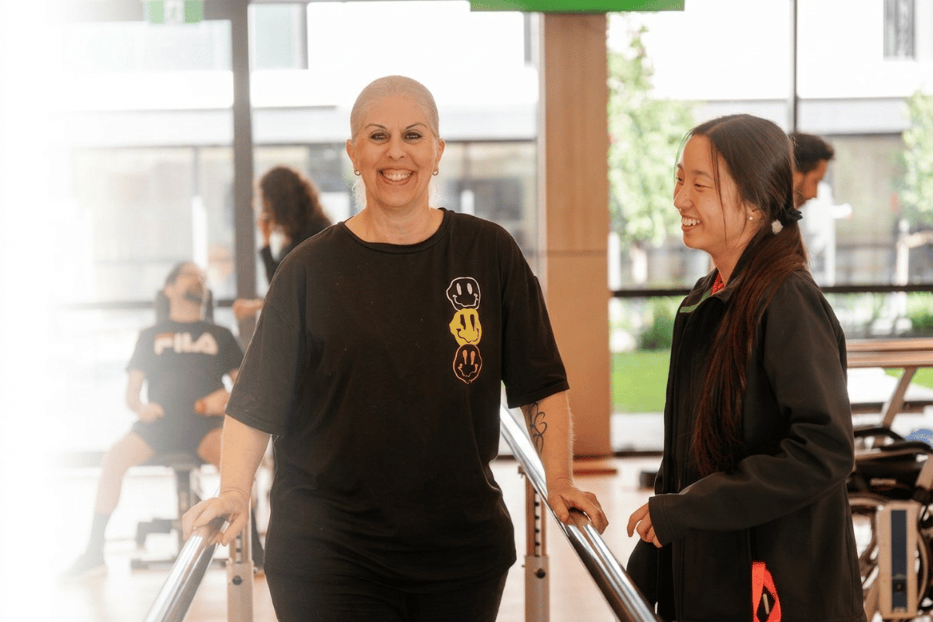 client in the lidcombe wellbeing gym wearing black with a health professional