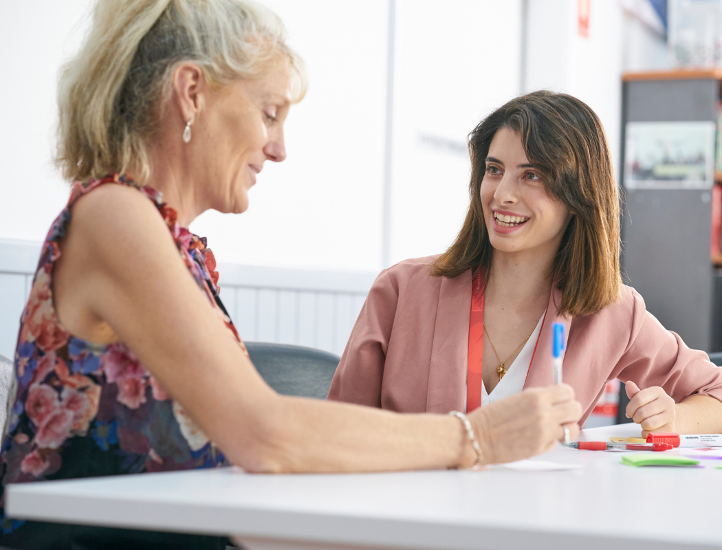 two women talking at table