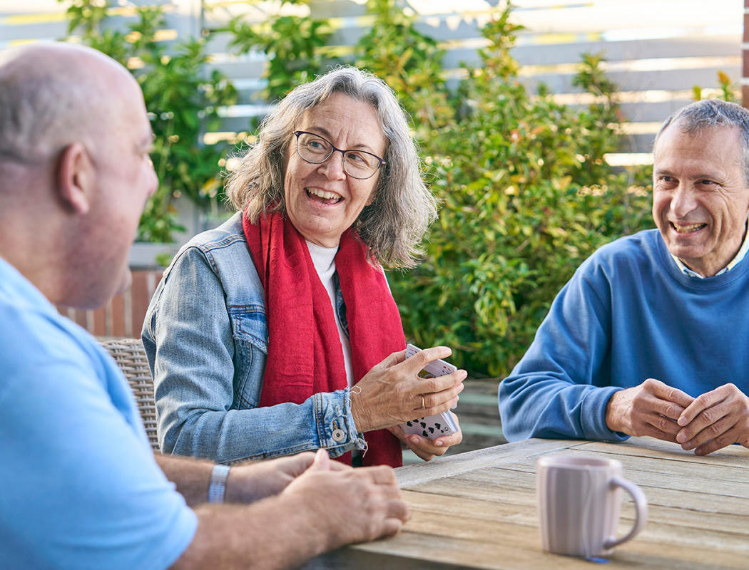 group of adults playing cards and smiling
