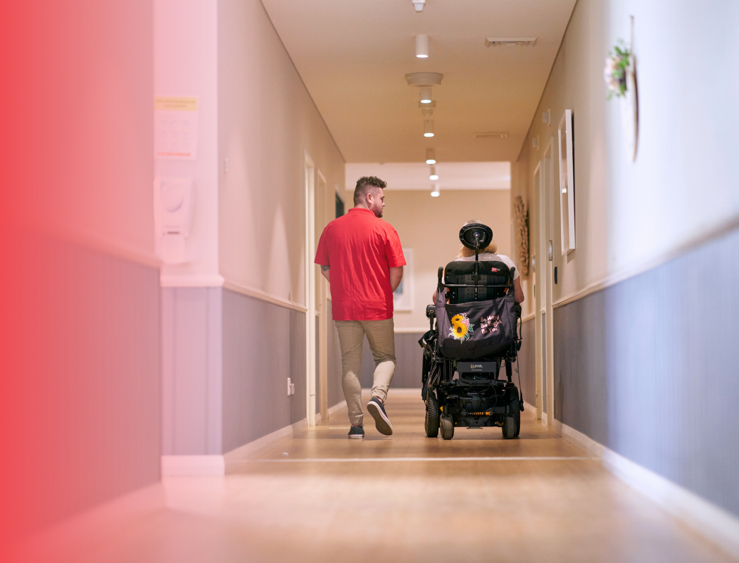man and woman on a wheelchair in corridor