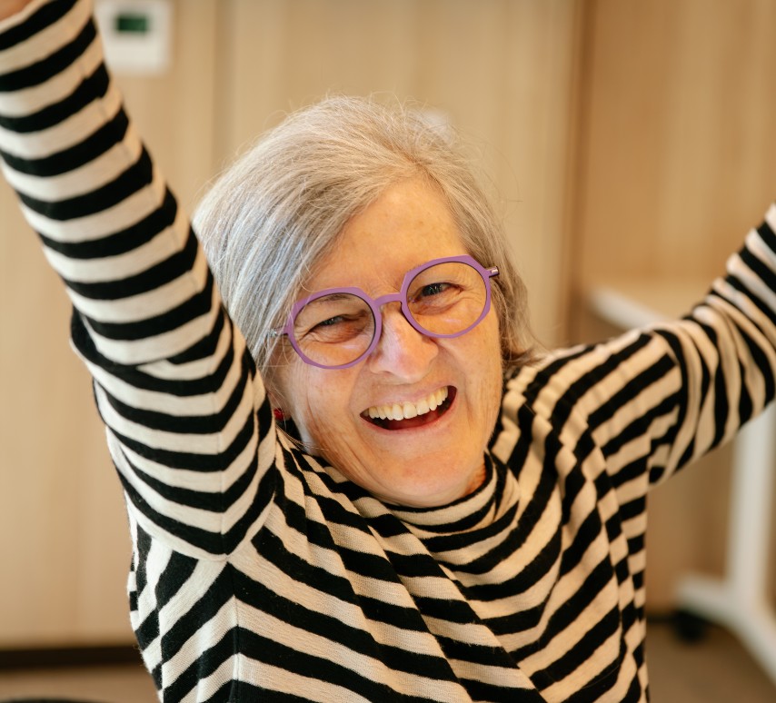 a women smiling with her hands up